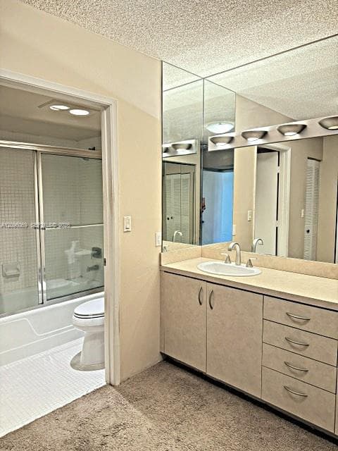 Bathroom vanity featuring solid-surface countertop, integrated oval sink, multi-drawer cabinetry, and full-width vanity mirror with integrated light fixture