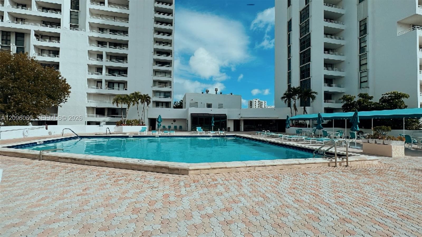 Swimming pool featuring a paved deck, surrounded by multi-story residential buildings with balconies