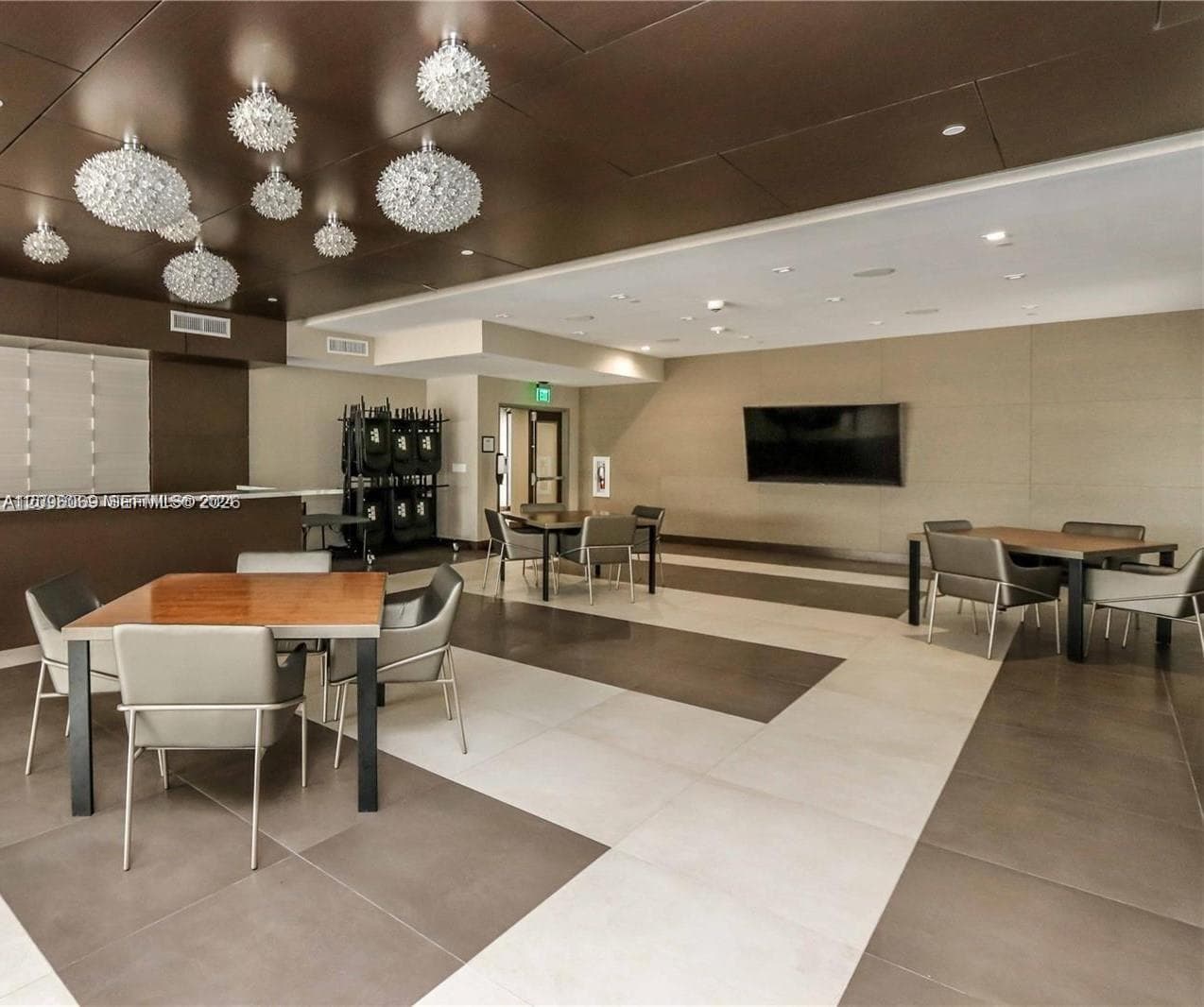 Large-format tile flooring, bronze-toned paneled ceiling, and multifaceted glass pendant light fixtures