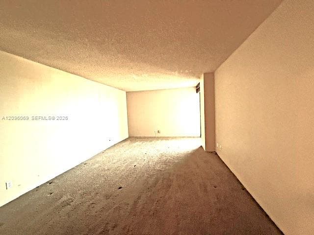Expansive interior room featuring neutral wall finishes and wall-to-wall carpeting