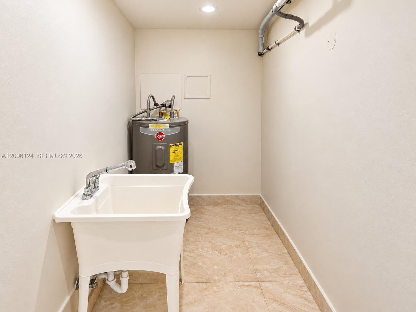 Utility area featuring ceramic tile flooring, recessed ceiling lighting, and a free-standing basin with a chrome faucet