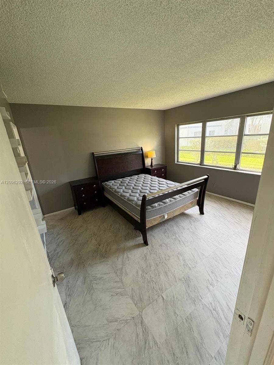 Light-toned stone-finish tile flooring, neutral wall coloring, and a multi-pane window configuration