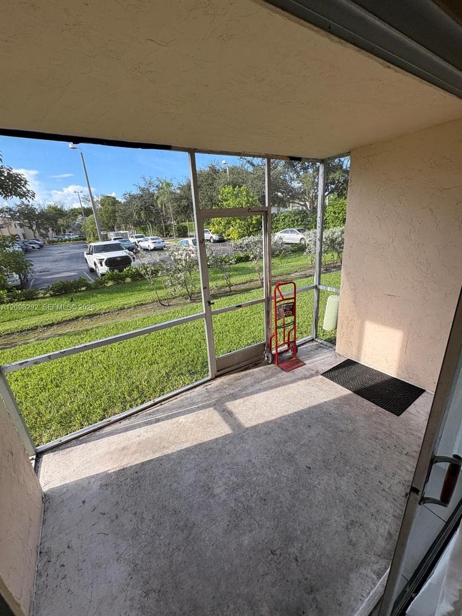 Screened-in porch featuring a concrete floor and stucco wall finishes