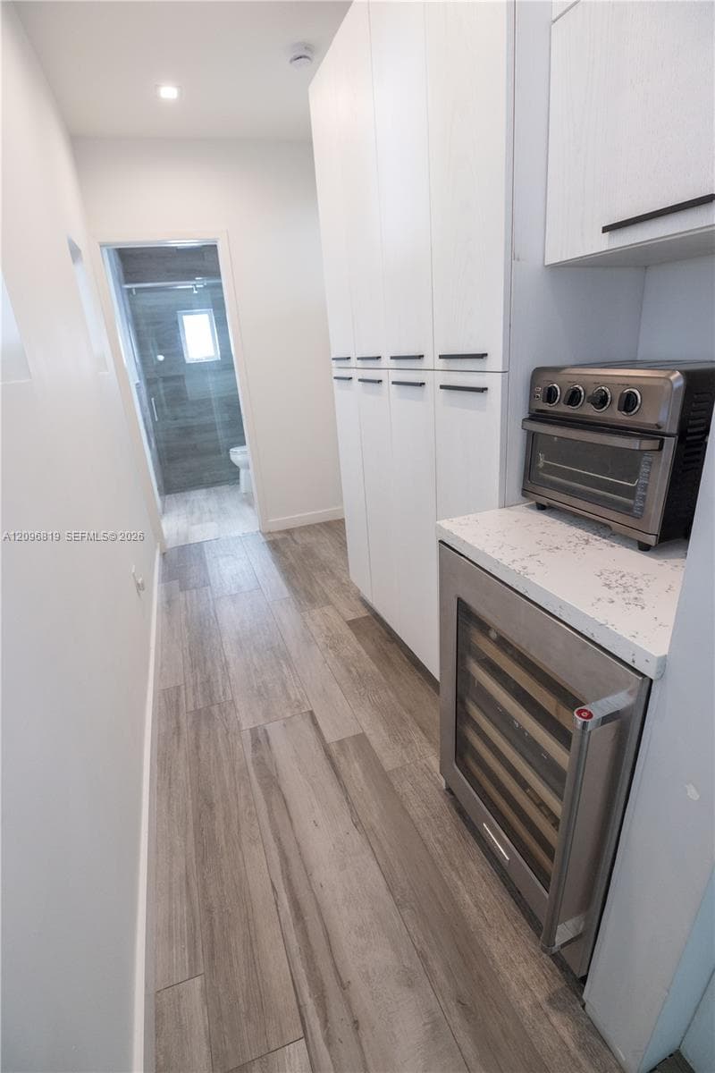 Custom Pantry Cabinetry with quartz countertop, built in wine cooler, and dedicated appliance garage for convenient concealed storage