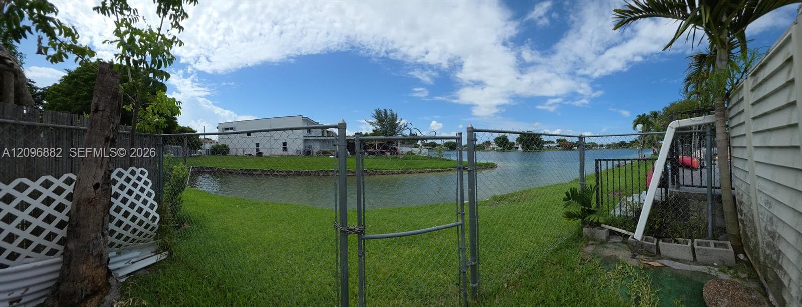 Beautiful waterfront setting featuring expansive lake views, lush green space, and direct access to the water from the property.