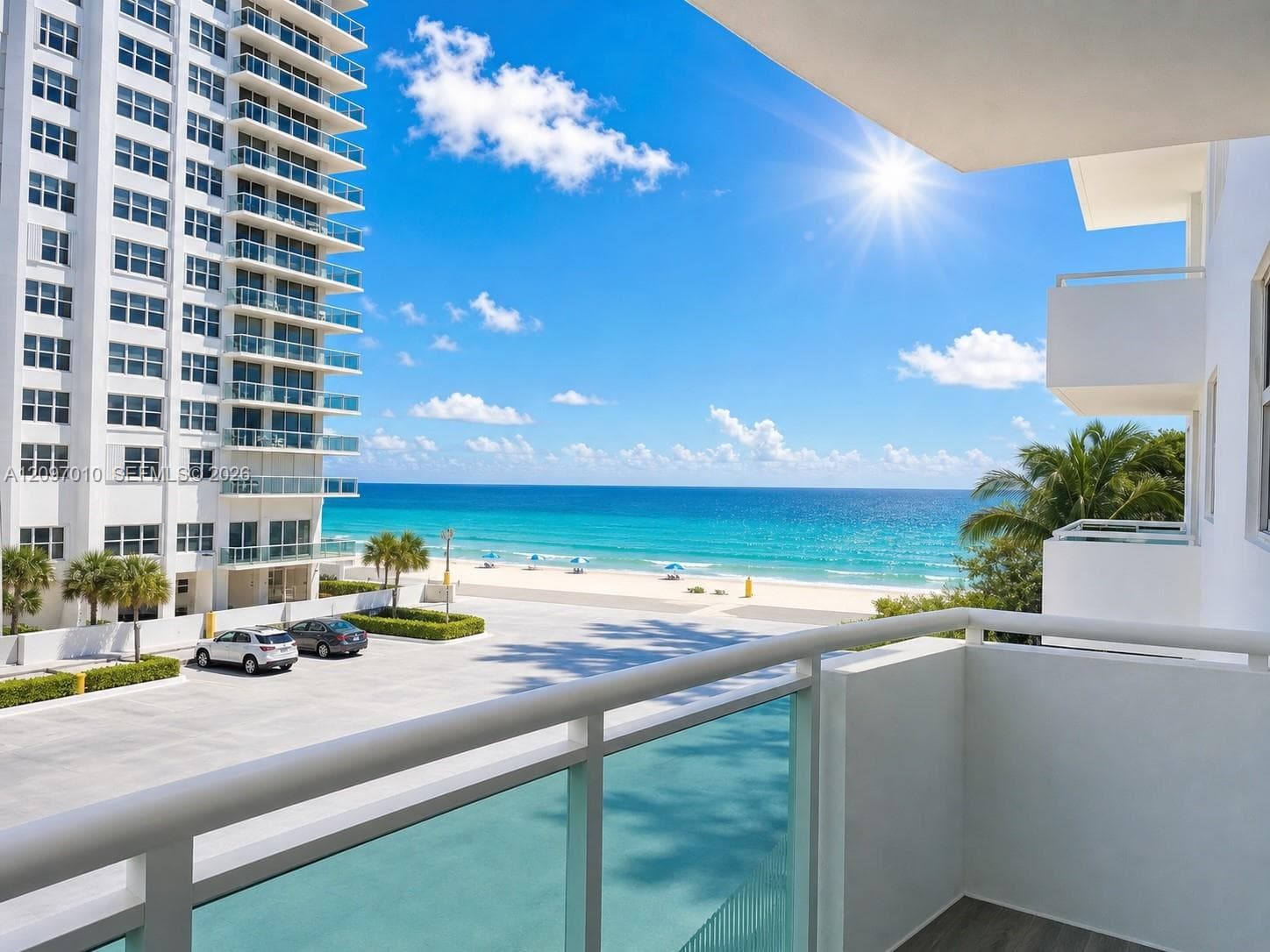 Private balcony featuring glass-panel railings and oceanfront scenery