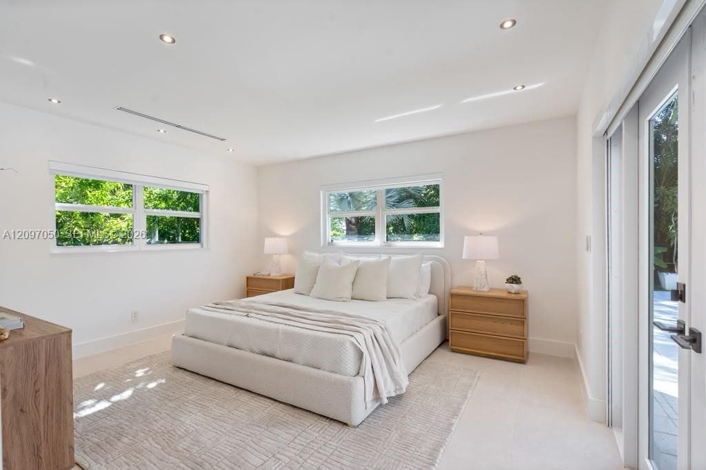 Bright interior space featuring recessed lighting, large dual-pane windows, and a glass-paneled door