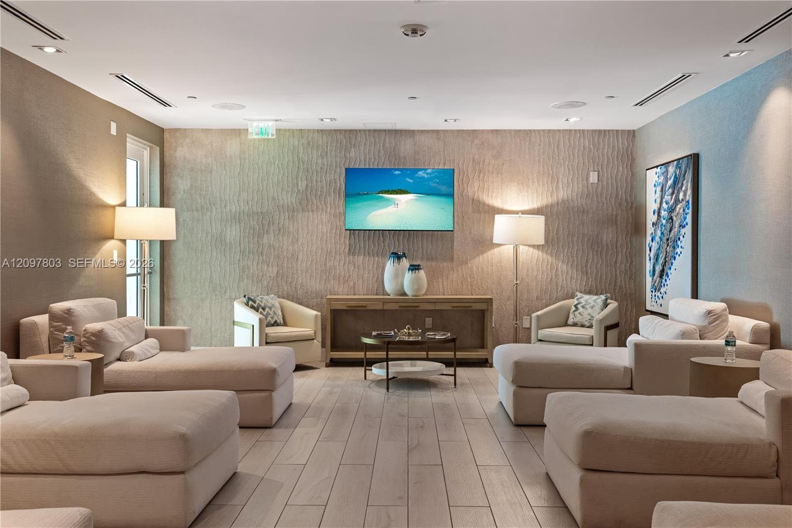 Textured accent wall, wood-finish flooring, recessed ceiling lighting, and built-in ceiling speakers