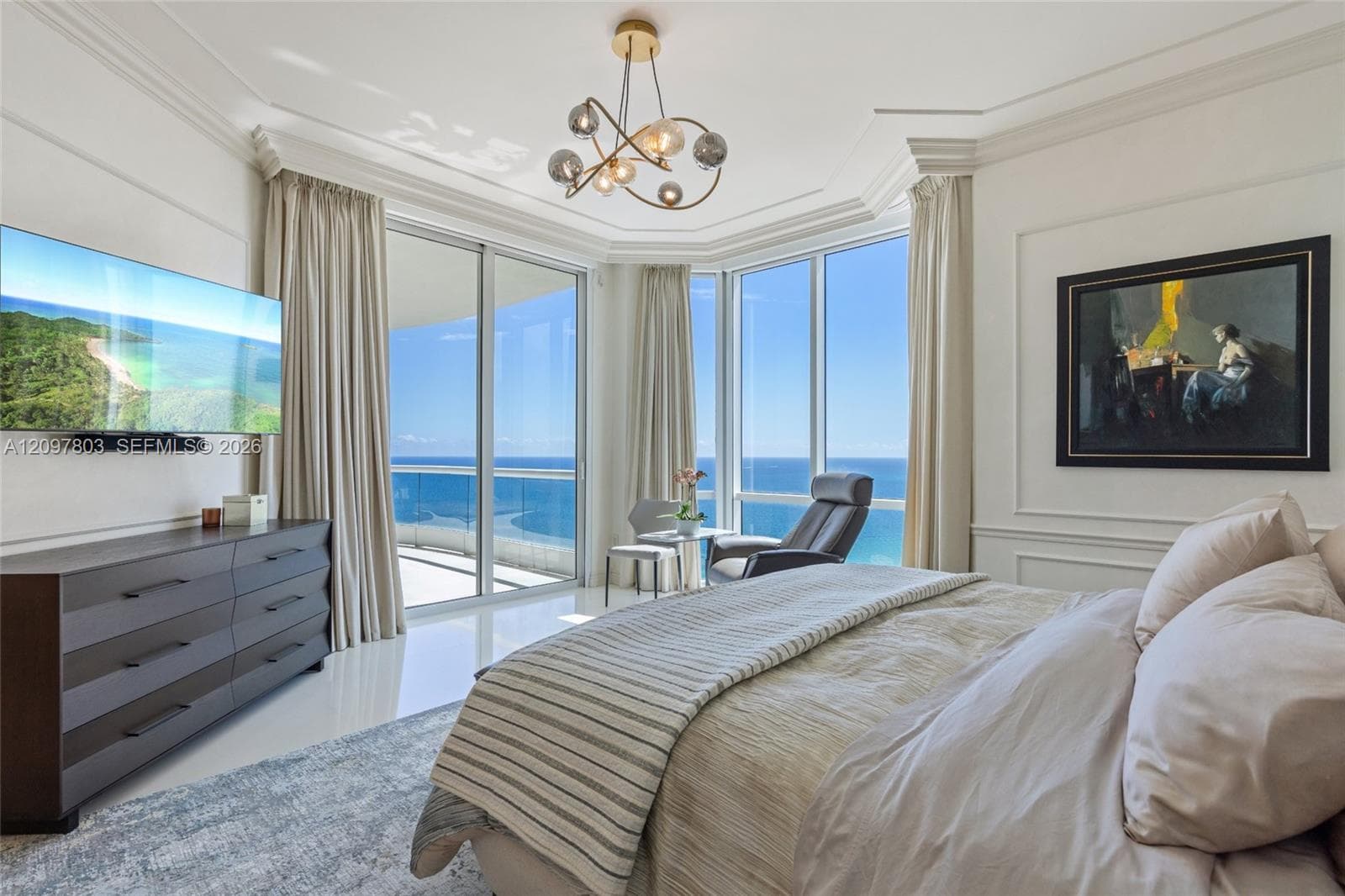 Floor-to-ceiling windows, panoramic ocean scenery, recessed lighting with a multi-light spherical fixture, high-gloss tile flooring, and wall panel molding