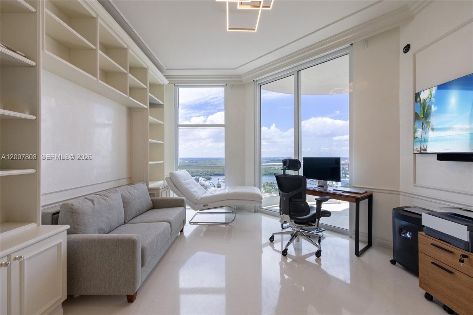 Floor-to-ceiling windows, built-in floor-to-ceiling shelving, light-toned polished flooring, crown molding, and geometric ceiling light fixture