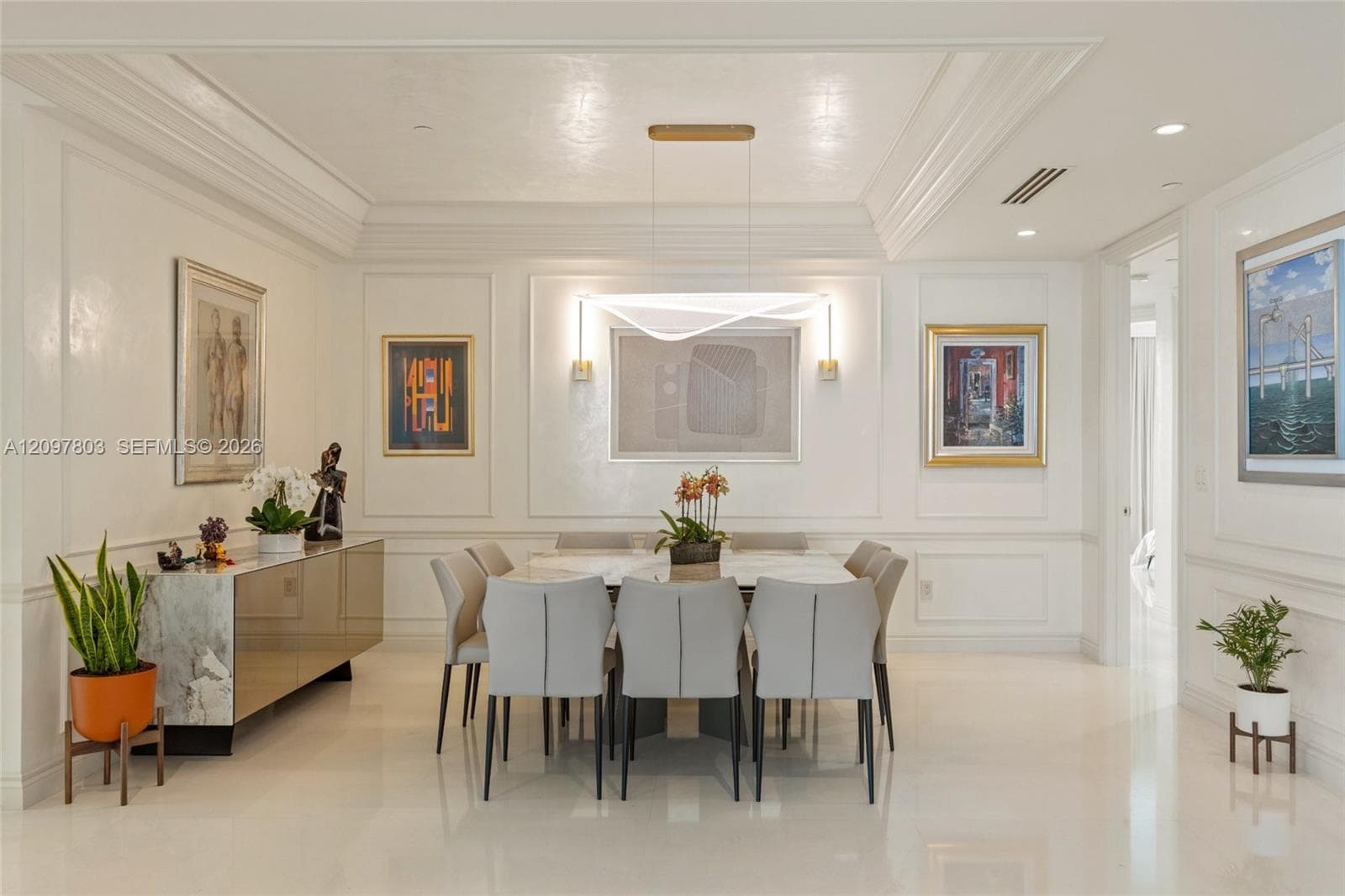 Tray ceiling with recessed lighting, intricate wall molding, polished flooring, and a modern sculptural pendant fixture
