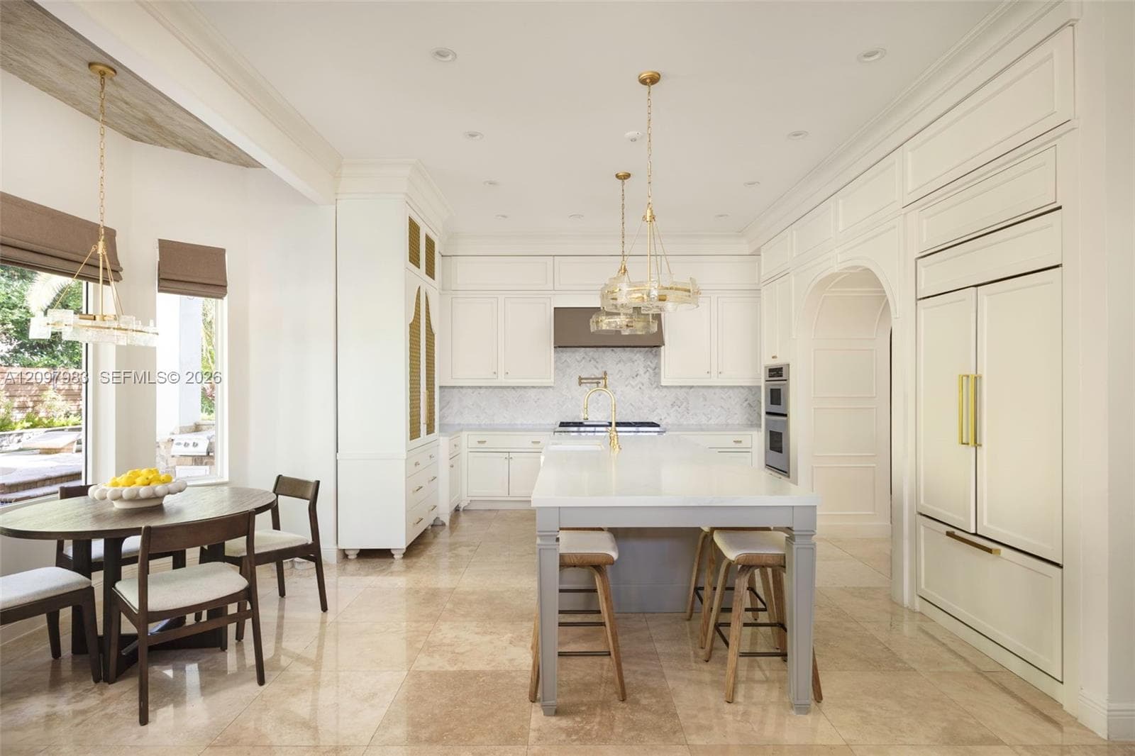 Kitchen featuring a central island with a stone countertop, custom cabinetry with panel-ready appliances, stone tile flooring, a tiled backsplash, and recessed pendant lighting