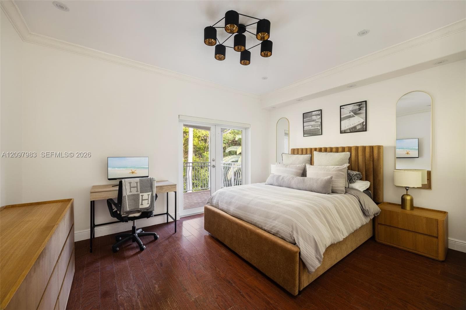 Wood-finish flooring, multi-light ceiling fixture, and French door access to an outdoor balcony