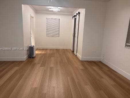 Wood-finish flooring, recessed ceiling lighting, and sliding barn-style closet doors