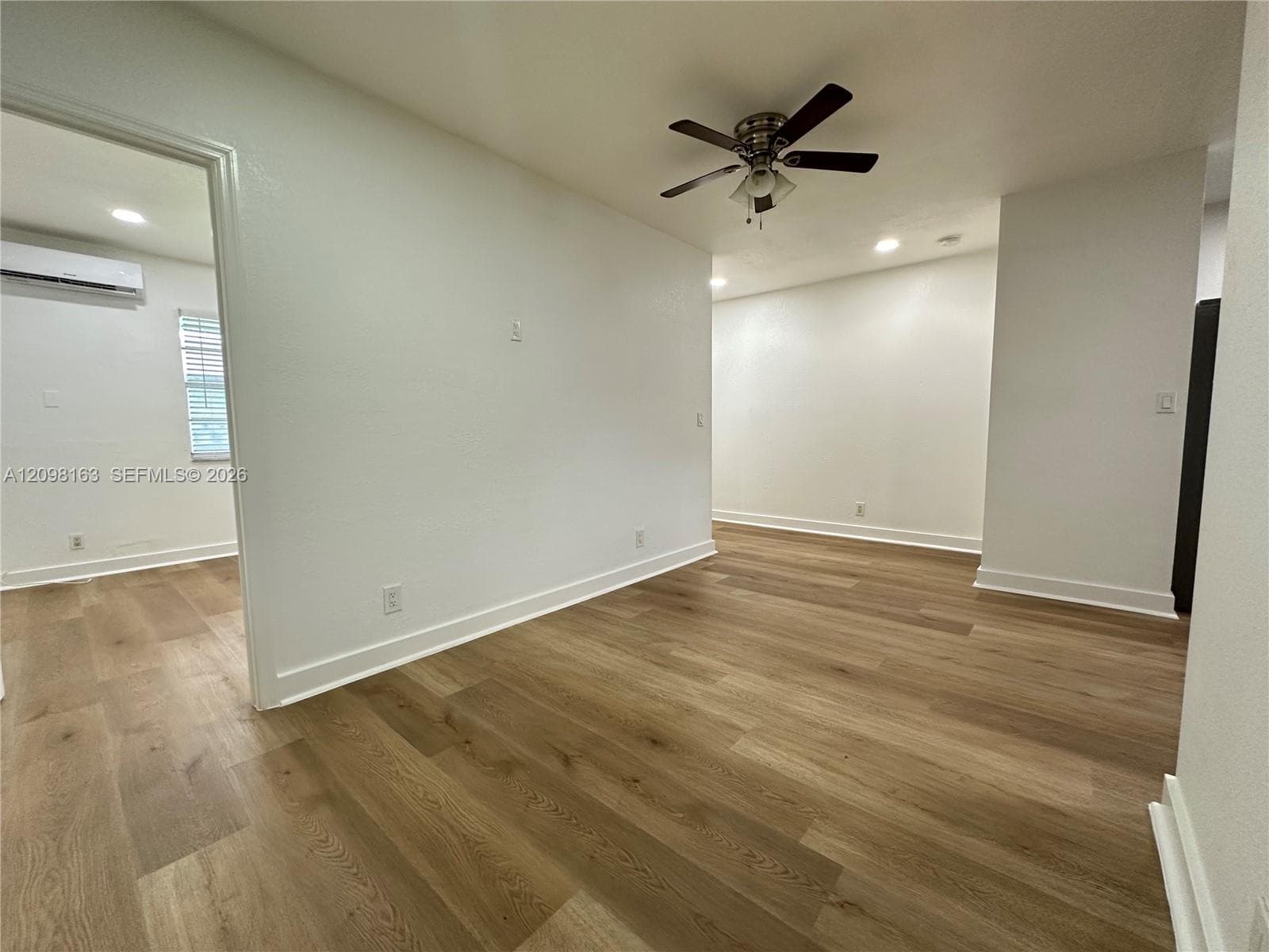 Neutral-toned interior featuring wood-finish flooring, recessed lighting, and a ceiling fan