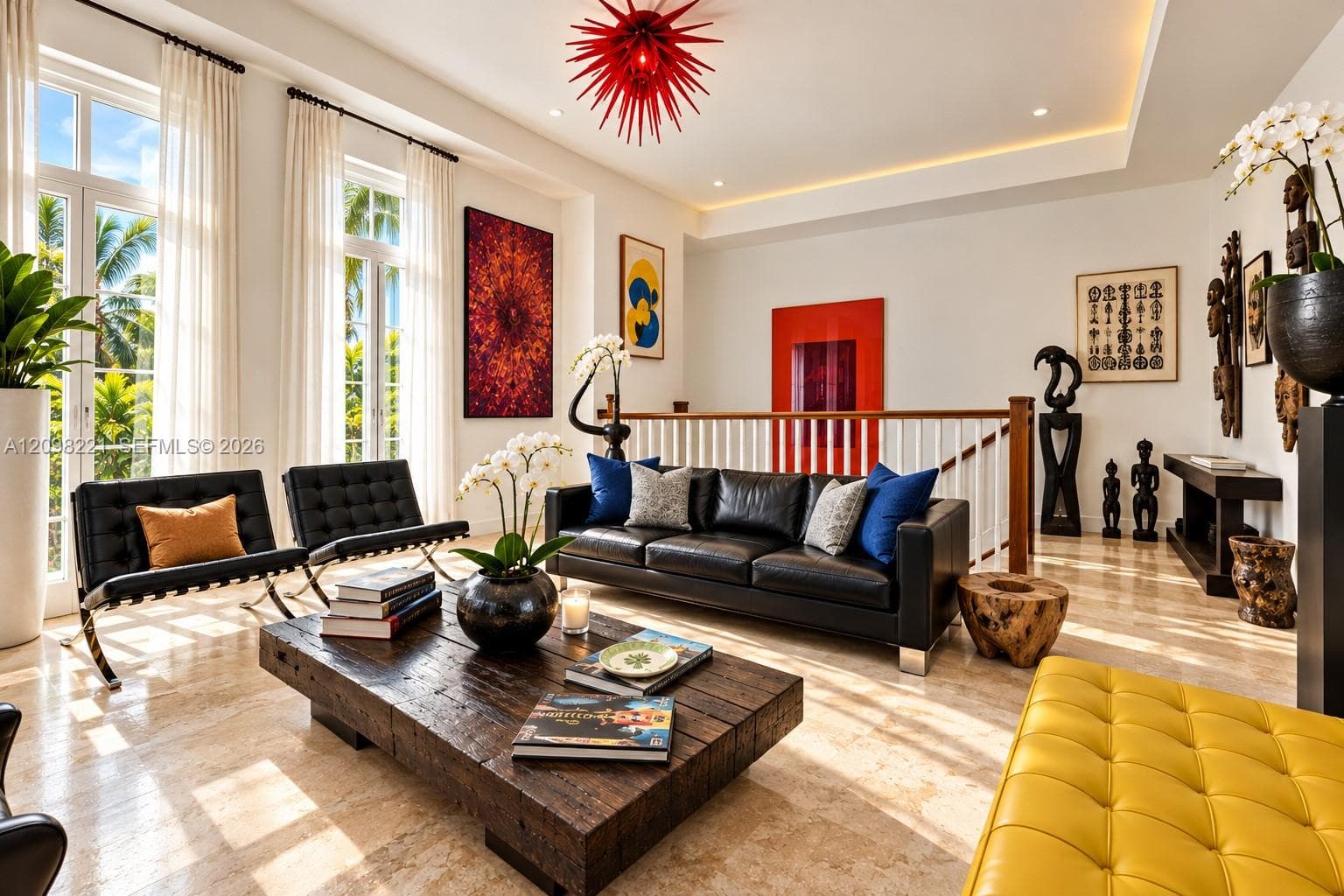 Open-concept room featuring natural stone flooring, recessed ceiling lighting with tray detailing, floor-to-ceiling windows, and a decorative red pendant fixture