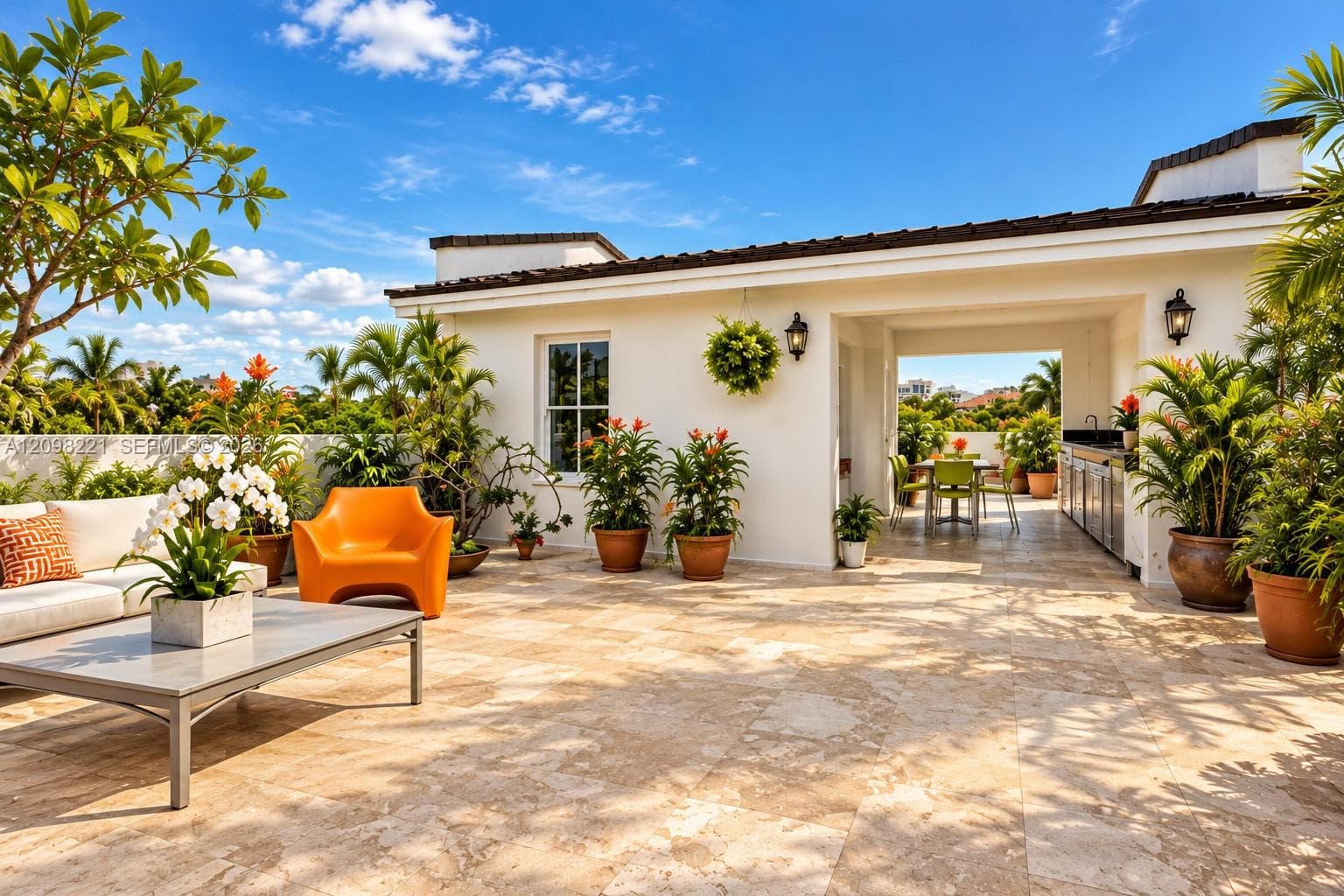 Rooftop terrace featuring stone tile flooring, a covered loggia, and a built-in outdoor kitchen with stainless steel cabinetry