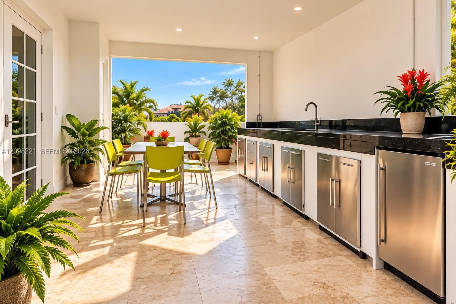 Covered outdoor loggia featuring stone tile flooring, recessed lighting, and a built-in outdoor kitchen with stainless steel under-counter cabinetry and stone countertops