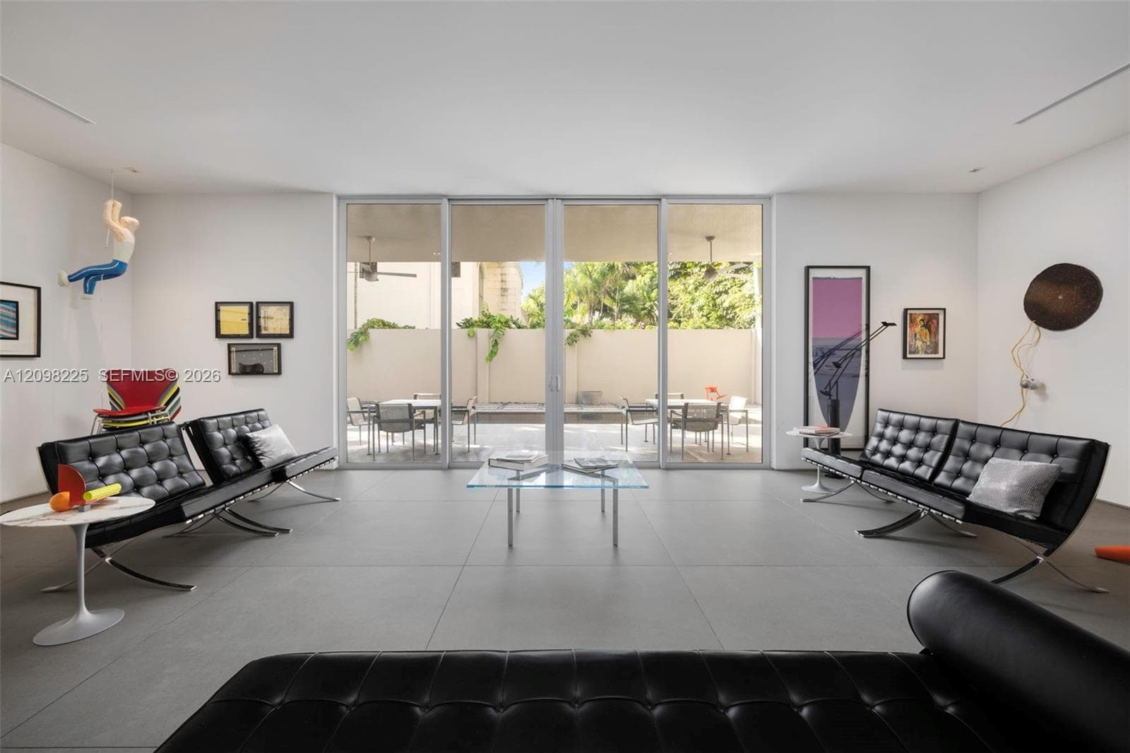 Living area featuring large-format tile flooring, recessed ceiling lighting, and expansive multi-panel sliding glass doors
