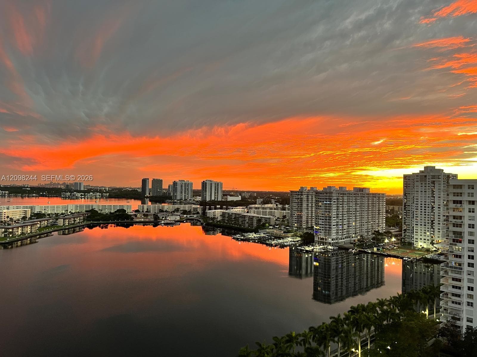 High-rise perspective featuring a sunset backdrop over an expansive waterway and metropolitan skyline