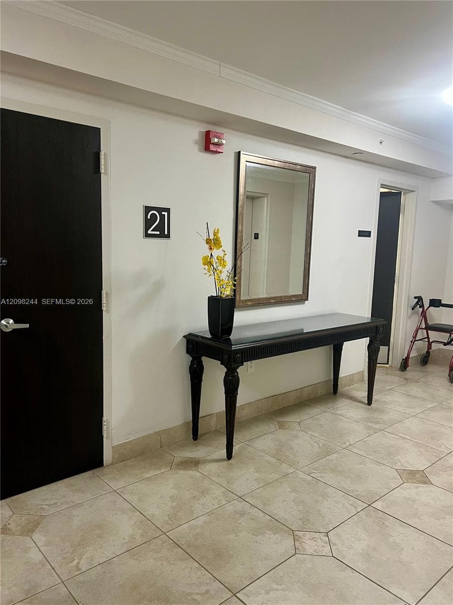Common area featuring large-format ceramic tile flooring and a wall-mounted fire safety alarm