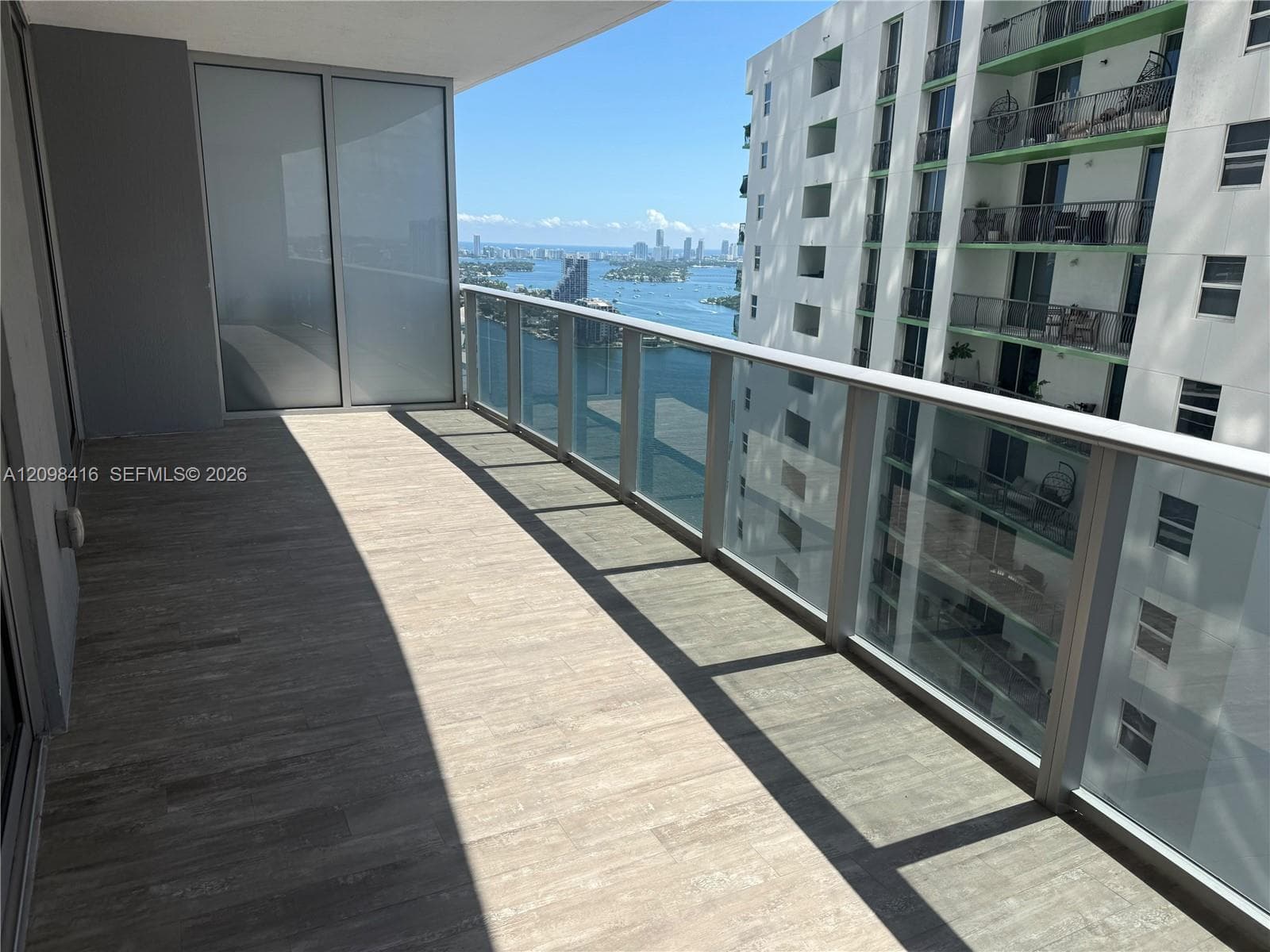 Balcony featuring a glass and aluminum railing, tile flooring, and sliding glass doors
