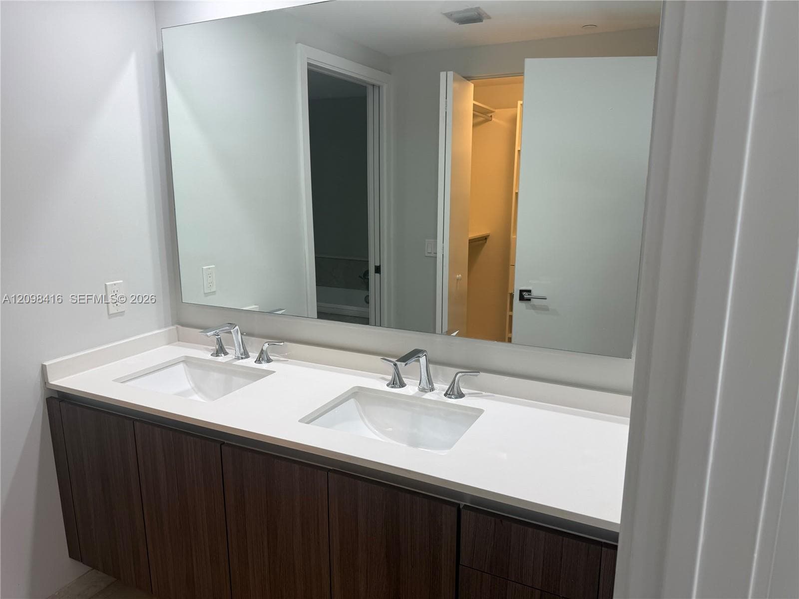 Double vanity with integrated rectangular sinks, chrome fixtures, and a light-toned countertop