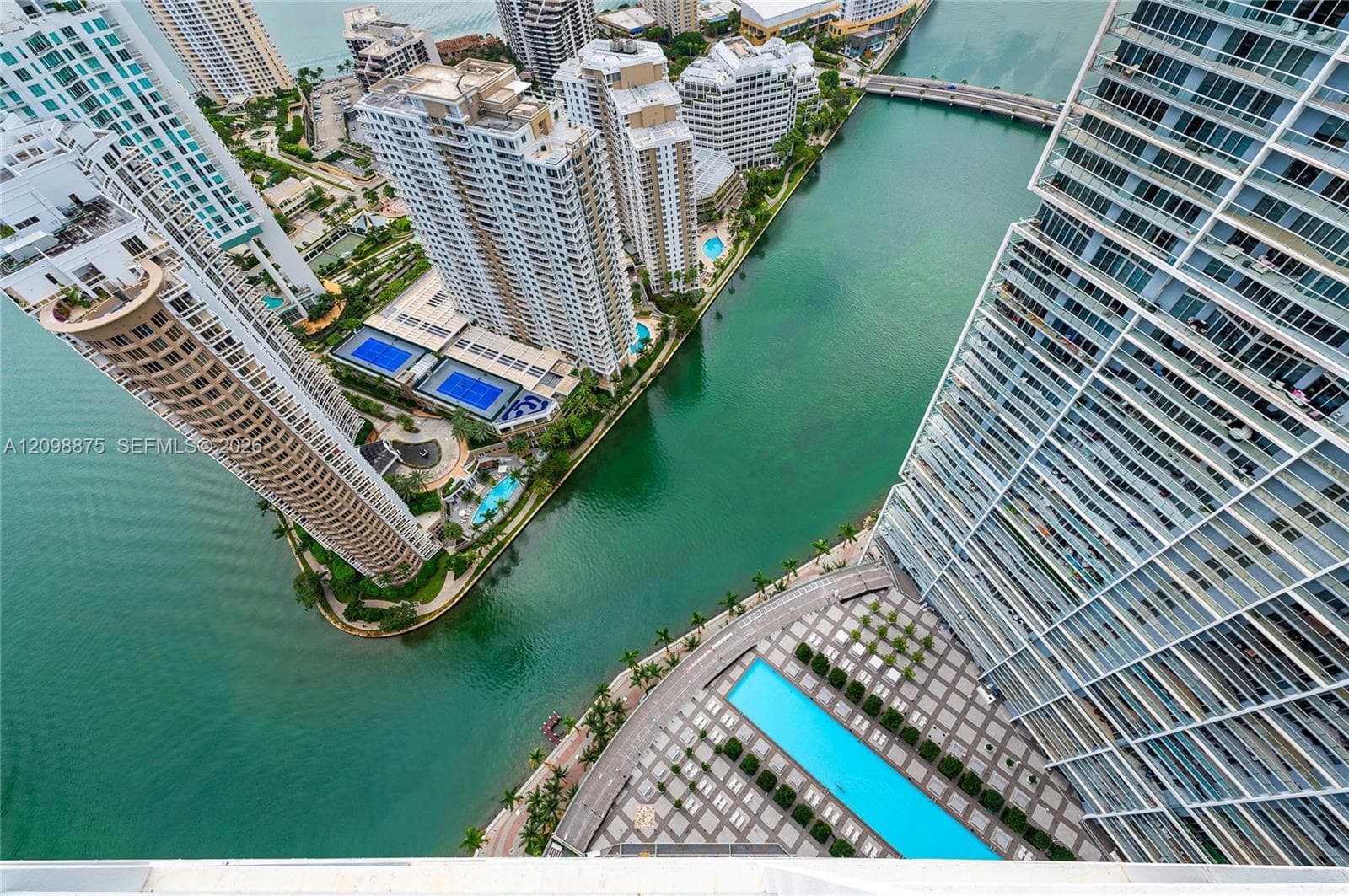 High-rise building with a rectangular pool, surrounded by a paved deck