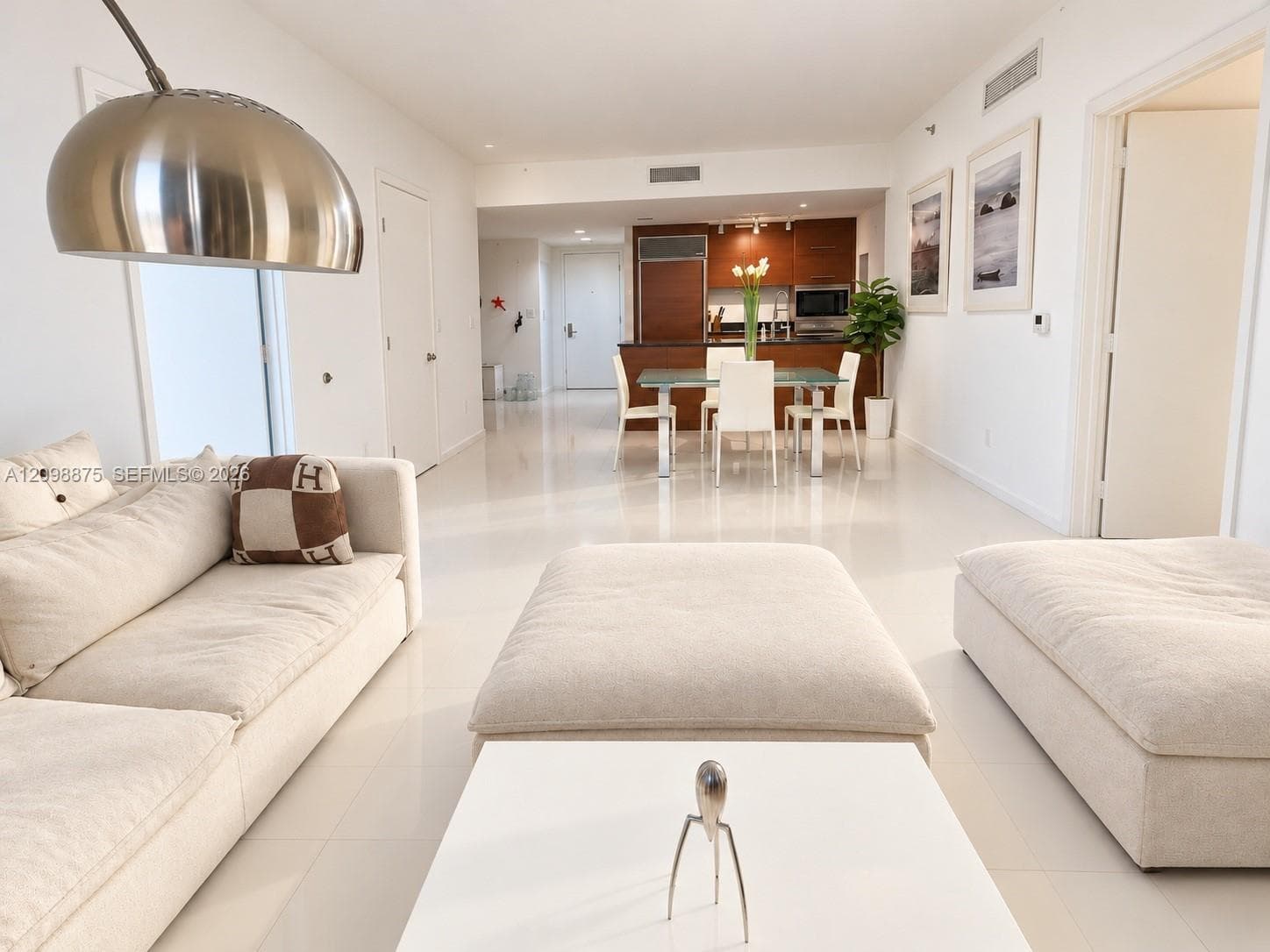 Open-concept living space featuring high ceilings and light-toned tile flooring