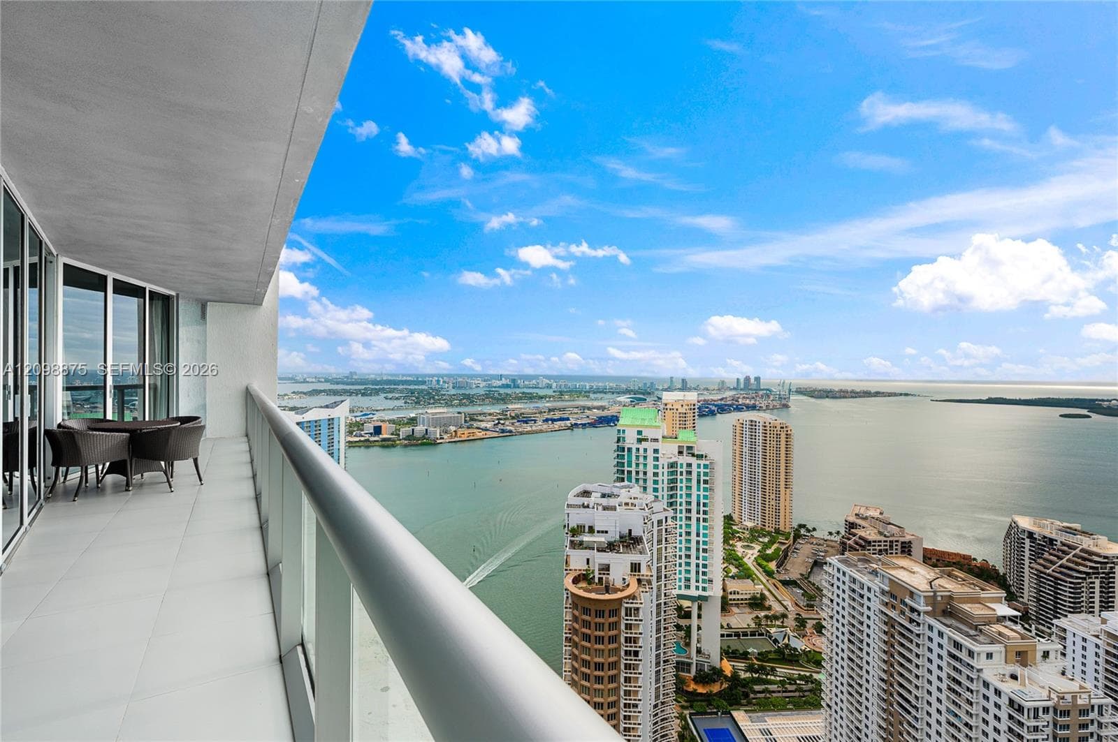 Expansive balcony with glass panel railing and cityscape water frontage