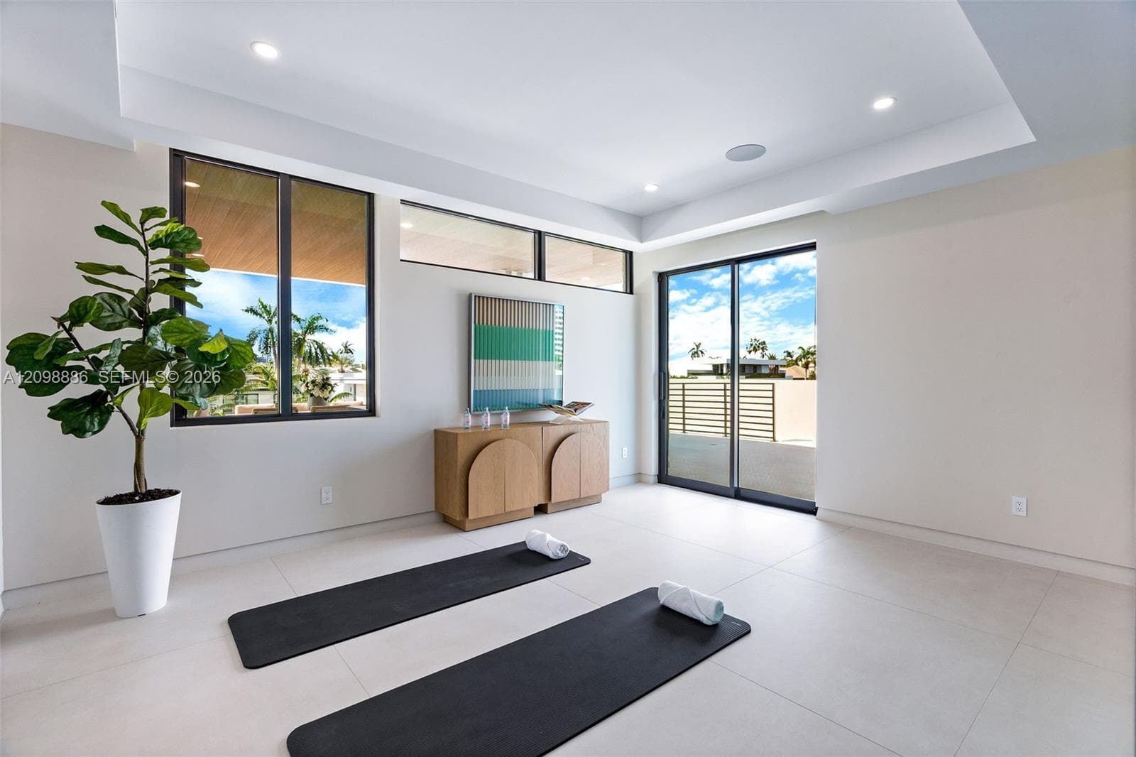 Interior space featuring large-format tile flooring, recessed ceiling lighting, clerestory windows, and glass sliding doors providing exterior exposure