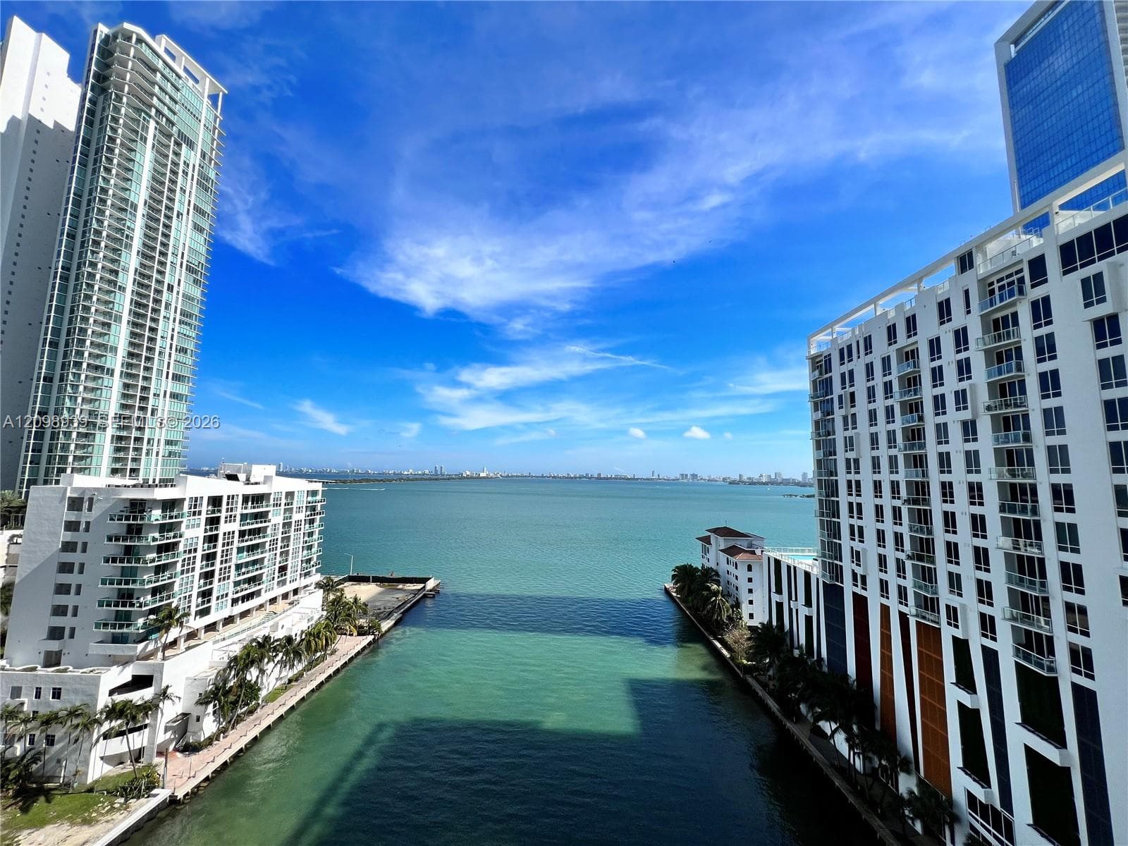Waterfront setting with a prominent canal, surrounded by high-rise buildings, and distant city skylines