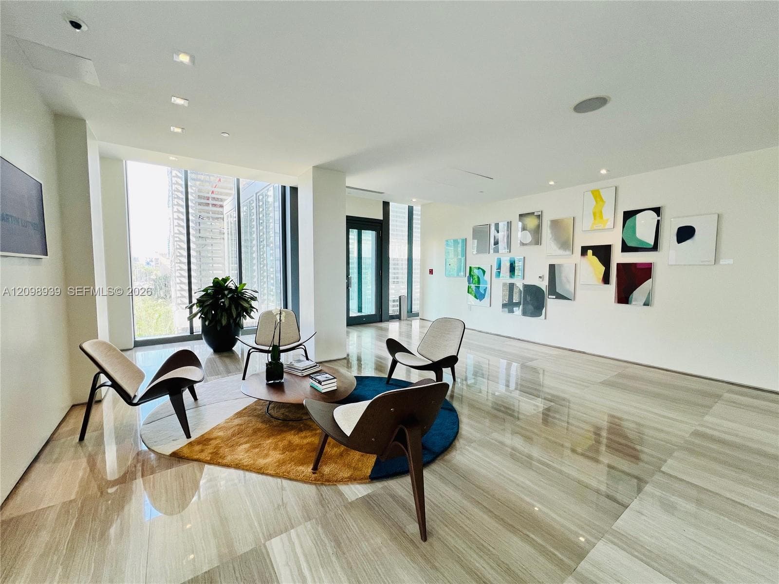Expansive white walls, light-toned polished flooring, recessed ceiling lighting, and floor-to-ceiling windows