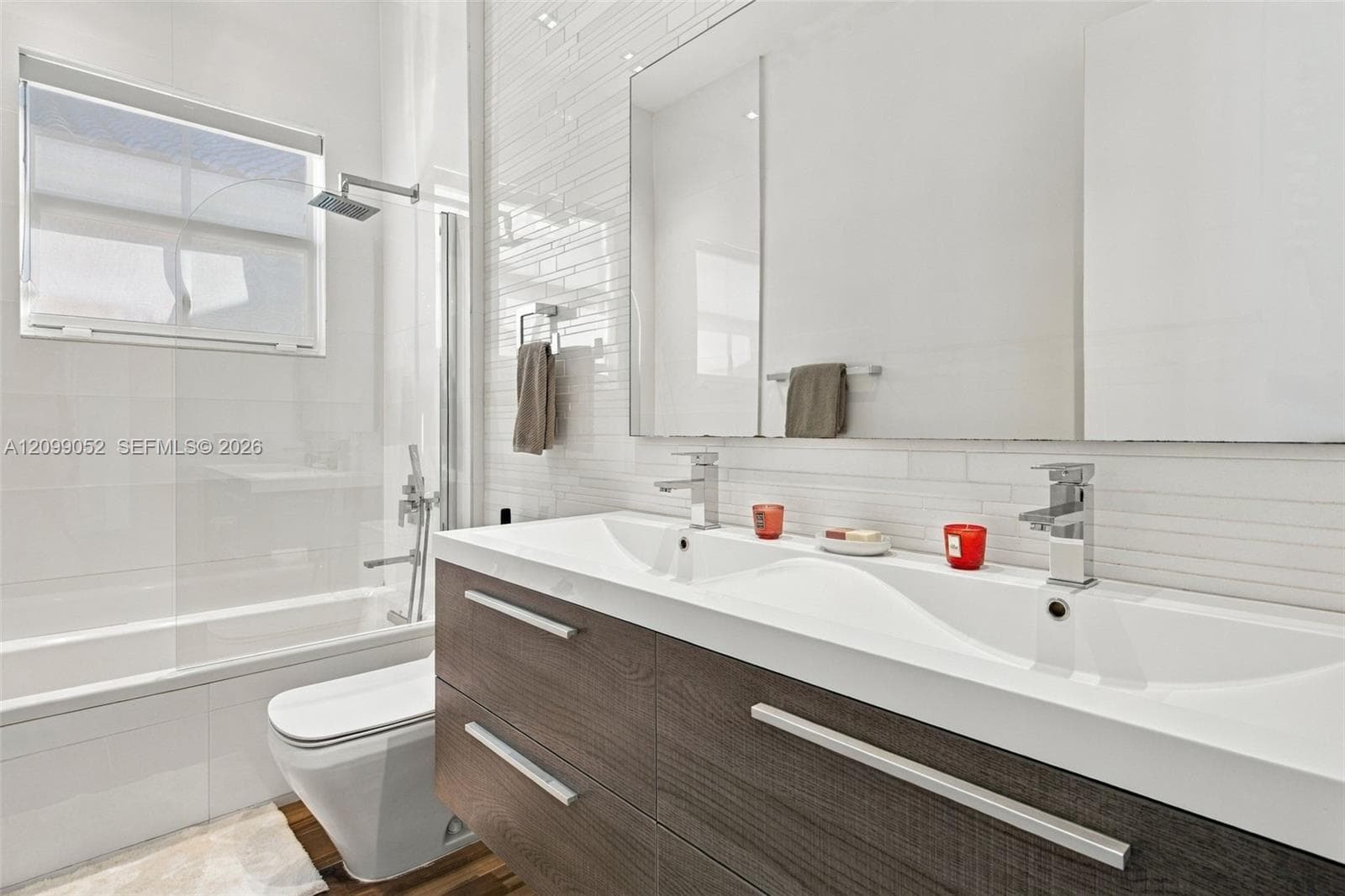 Floating dual-sink vanity with wood-finish cabinetry, rectangular under-mount sinks, and polished chrome faucets