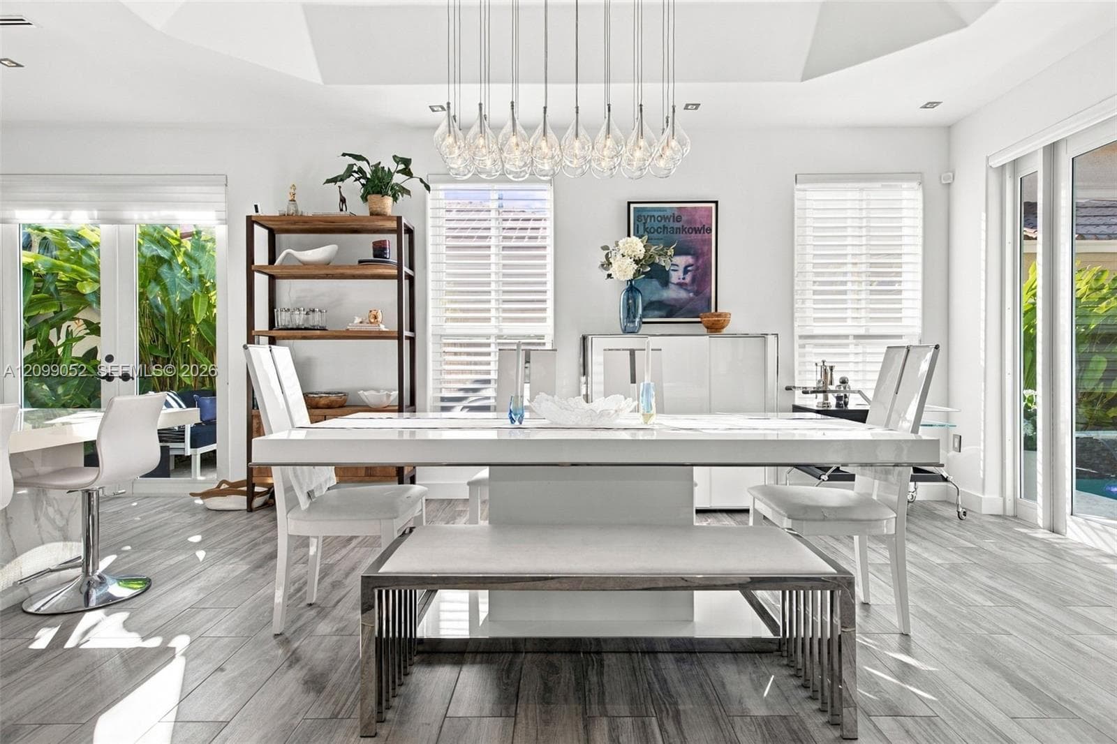 Dining area featuring a recessed tray ceiling, wood-finish tile flooring, and a multi-pendant chandelier