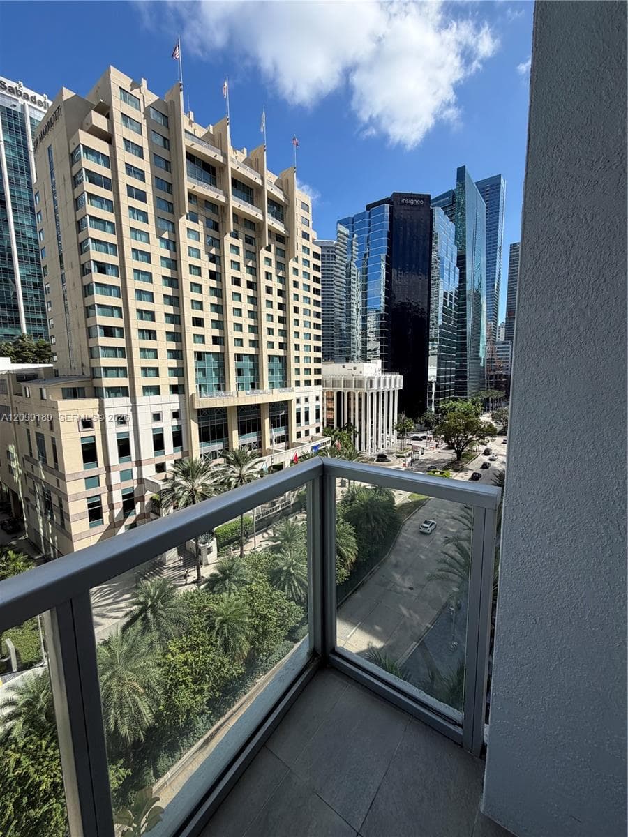 Private balcony featuring tile flooring and a glass-paneled railing