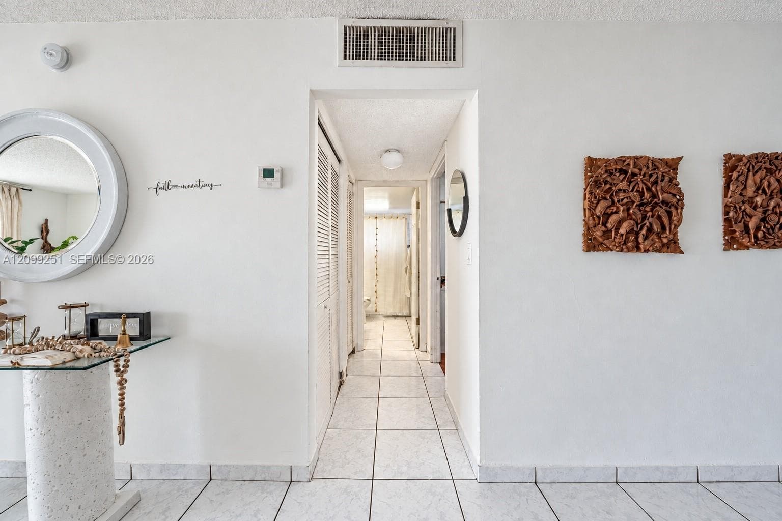 White tile flooring, white walls, and a recessed hallway
