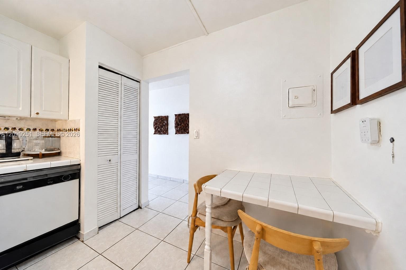 Kitchenette featuring white cabinetry, tile backsplash, built-in dishwasher, and white tiled flooring