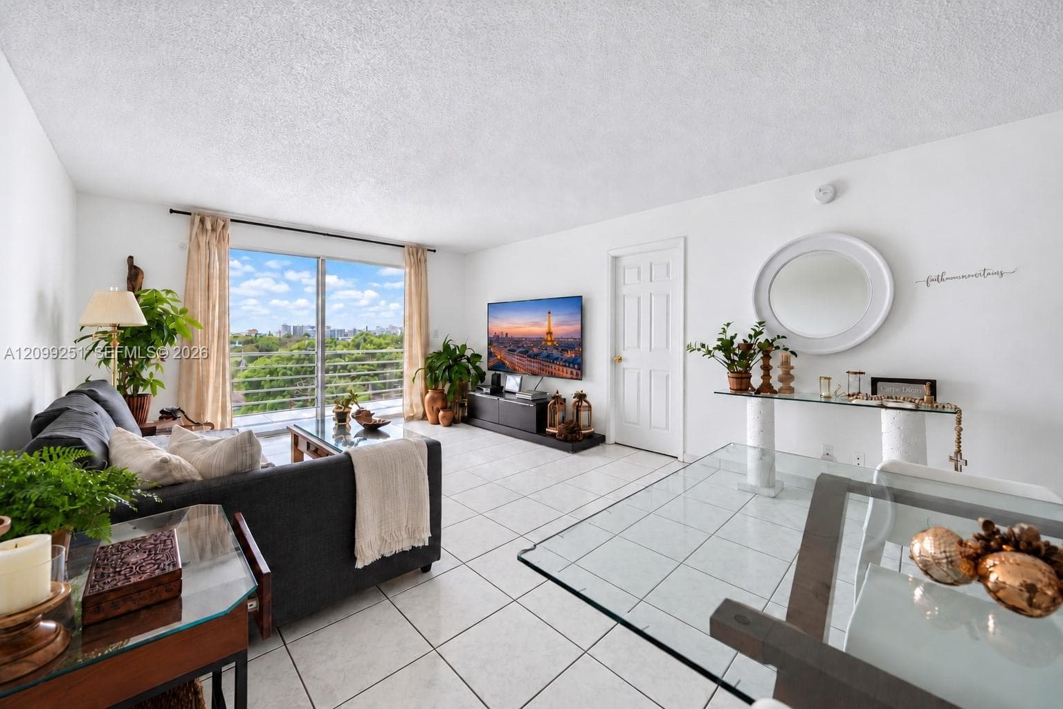 White tile flooring, sliding glass patio doors, white paneled interior door, glass-top console table with white bases, and a ceiling-mounted light fixture