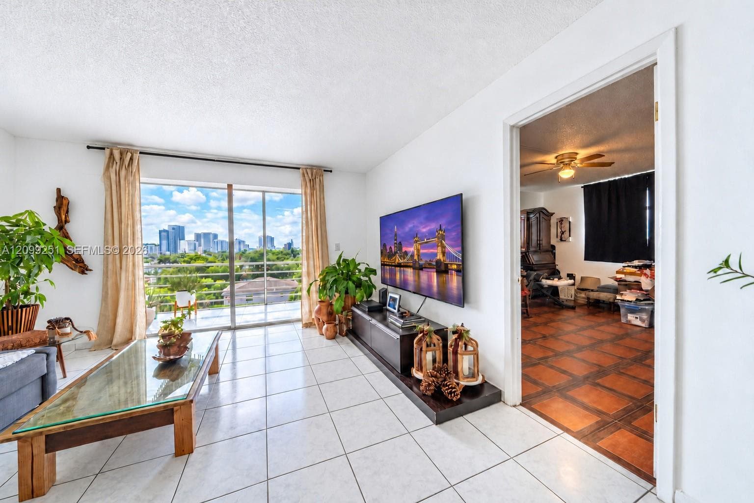 White tile flooring, sliding glass door, city skyline, balcony access, white walls