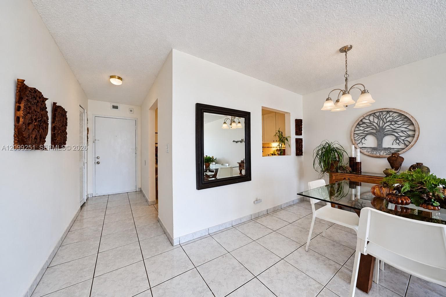 White tile flooring, pass-through window, and a ceiling-mounted light fixture with four glass shades