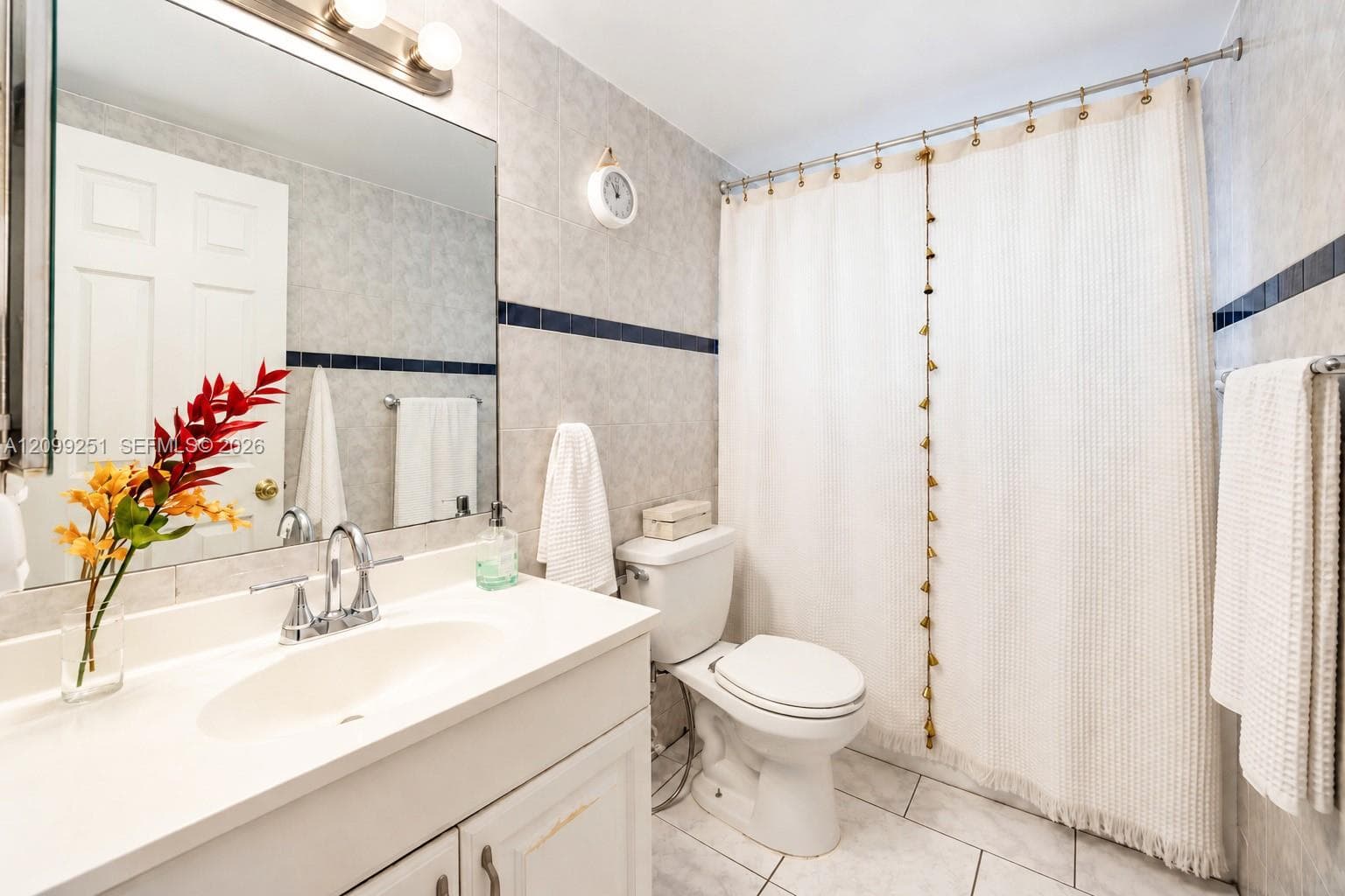 Vanity with an integrated sink, polished chrome faucet, and overhead bar lighting