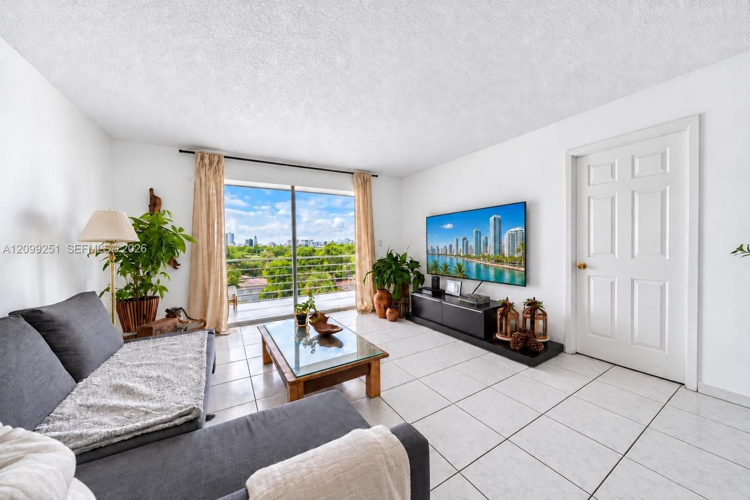 White tile flooring, white walls, and a white six-panel door with a brass knob