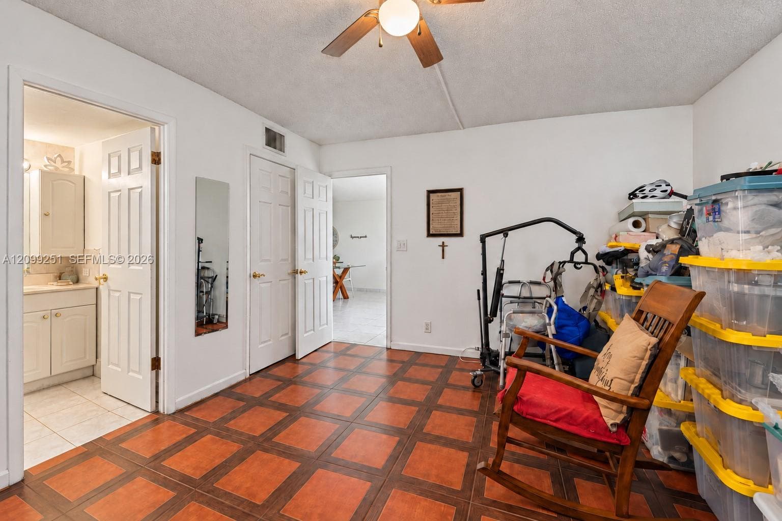Tile flooring with a geometric pattern, ceiling fan, and white painted walls