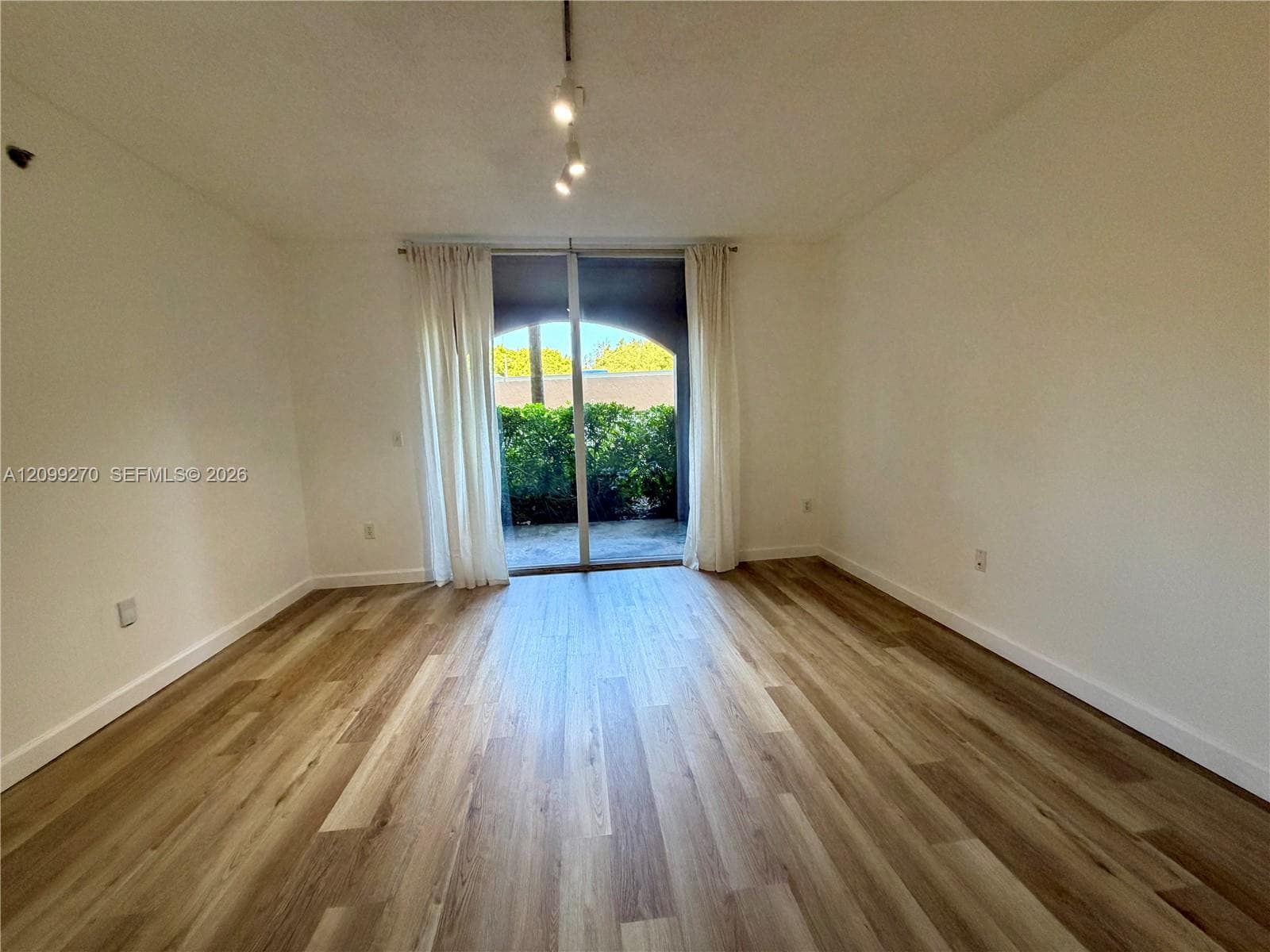 Wood-finish flooring, sliding glass patio door, and multi-bulb pendant lighting fixture