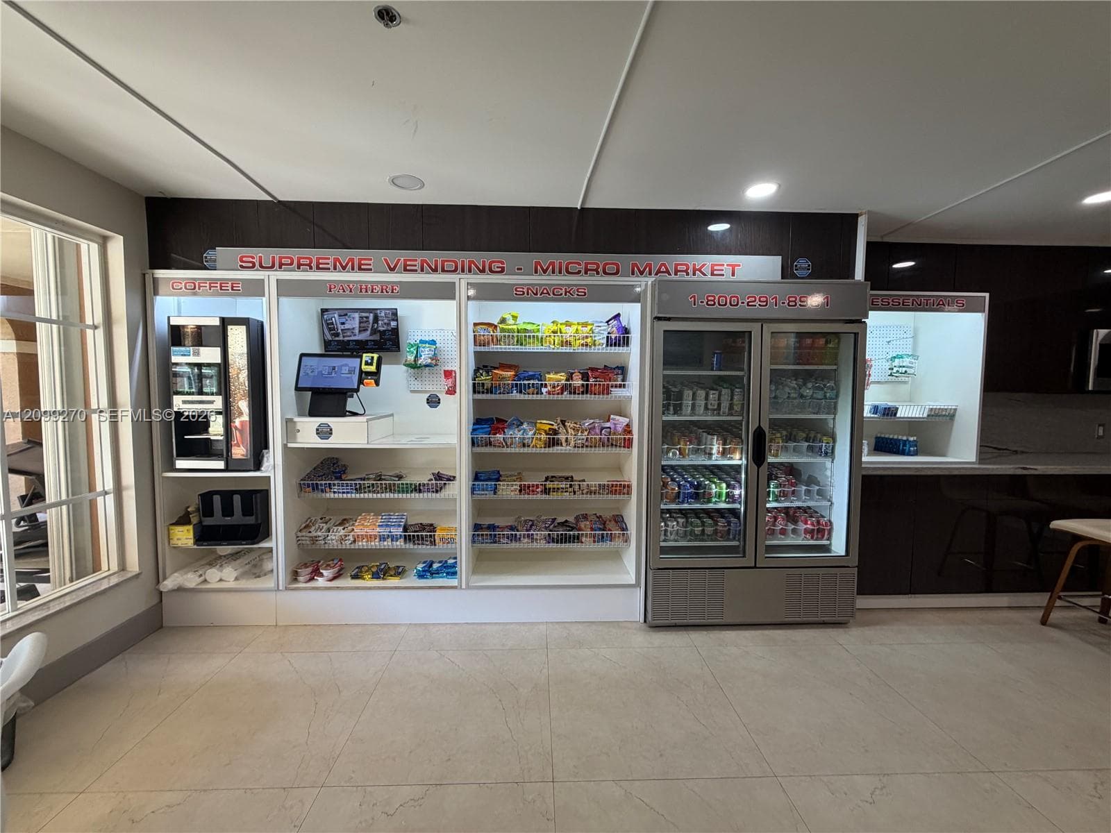 On-site micro-market featuring integrated refrigeration, open-shelf display units, an automated beverage station, and a built-in payment kiosk with tile flooring