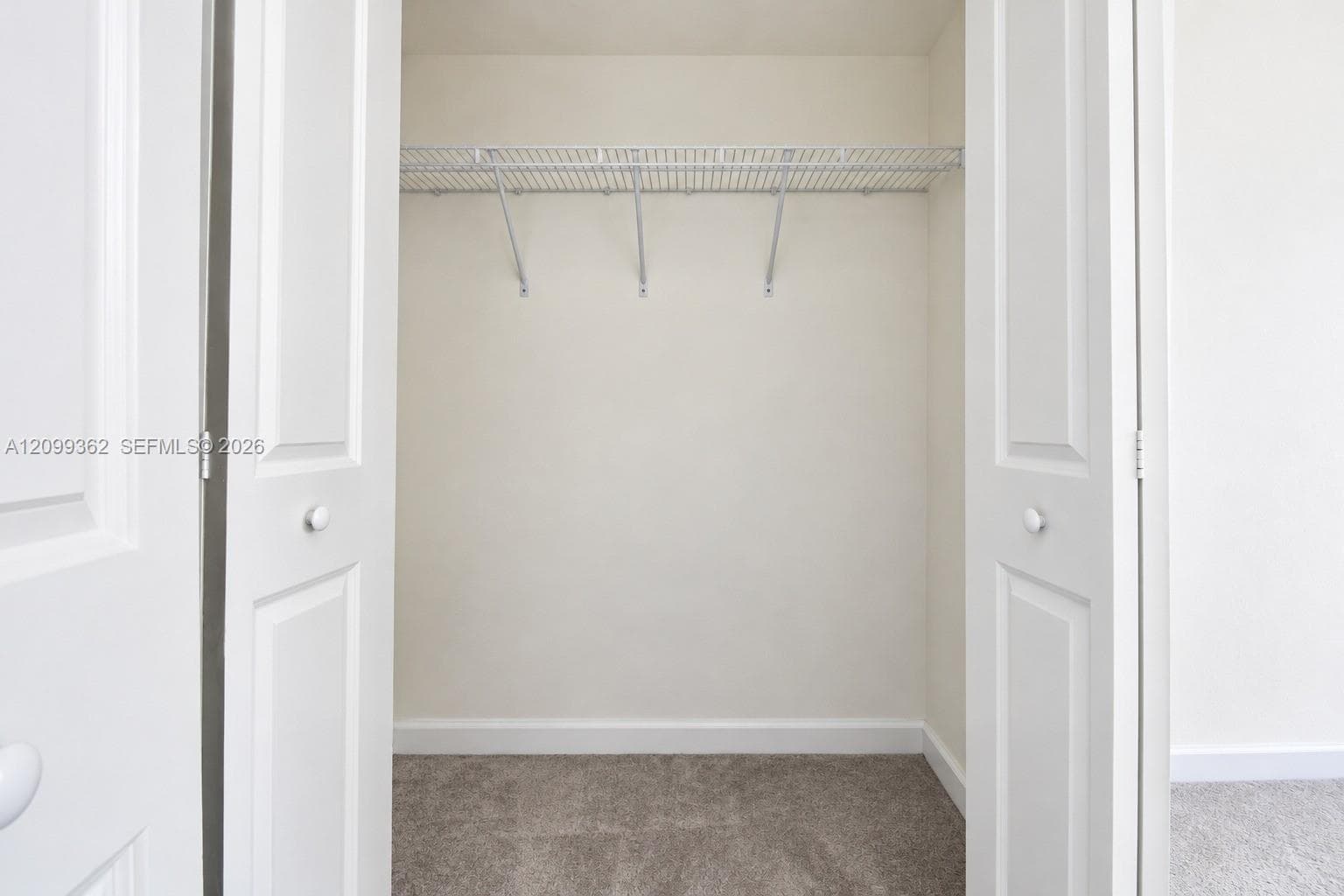 Closet featuring white bi-fold doors and overhead wire shelving