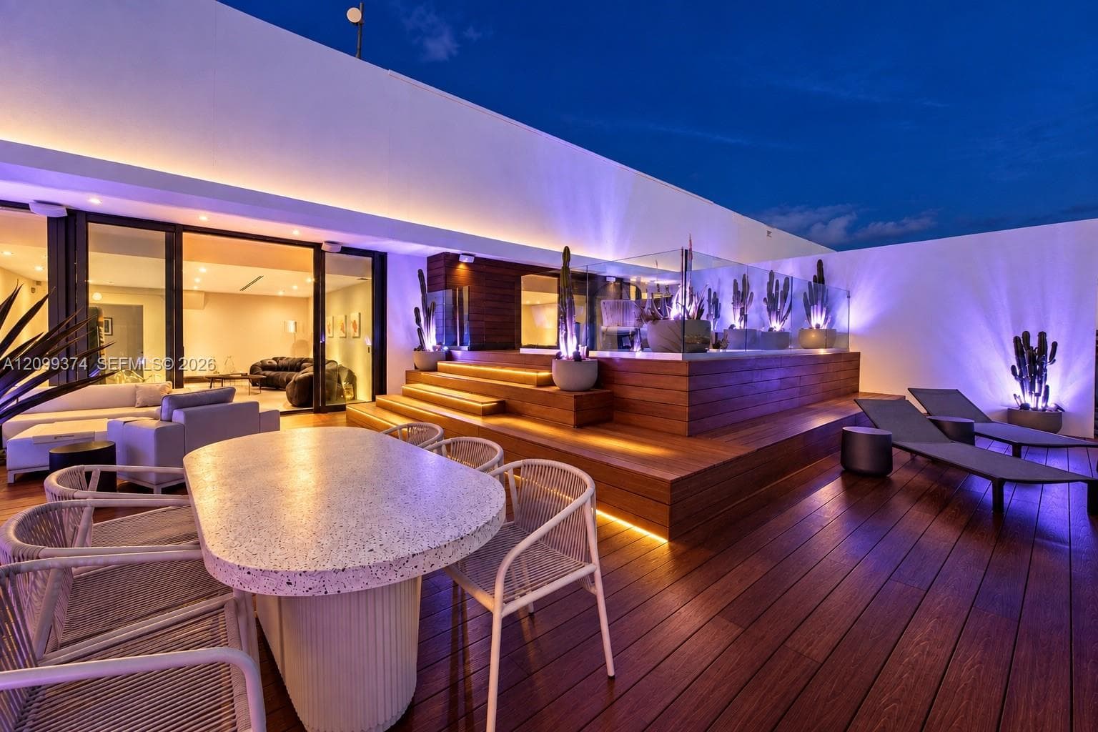 Rooftop dining and lounge areas illuminated at twilight