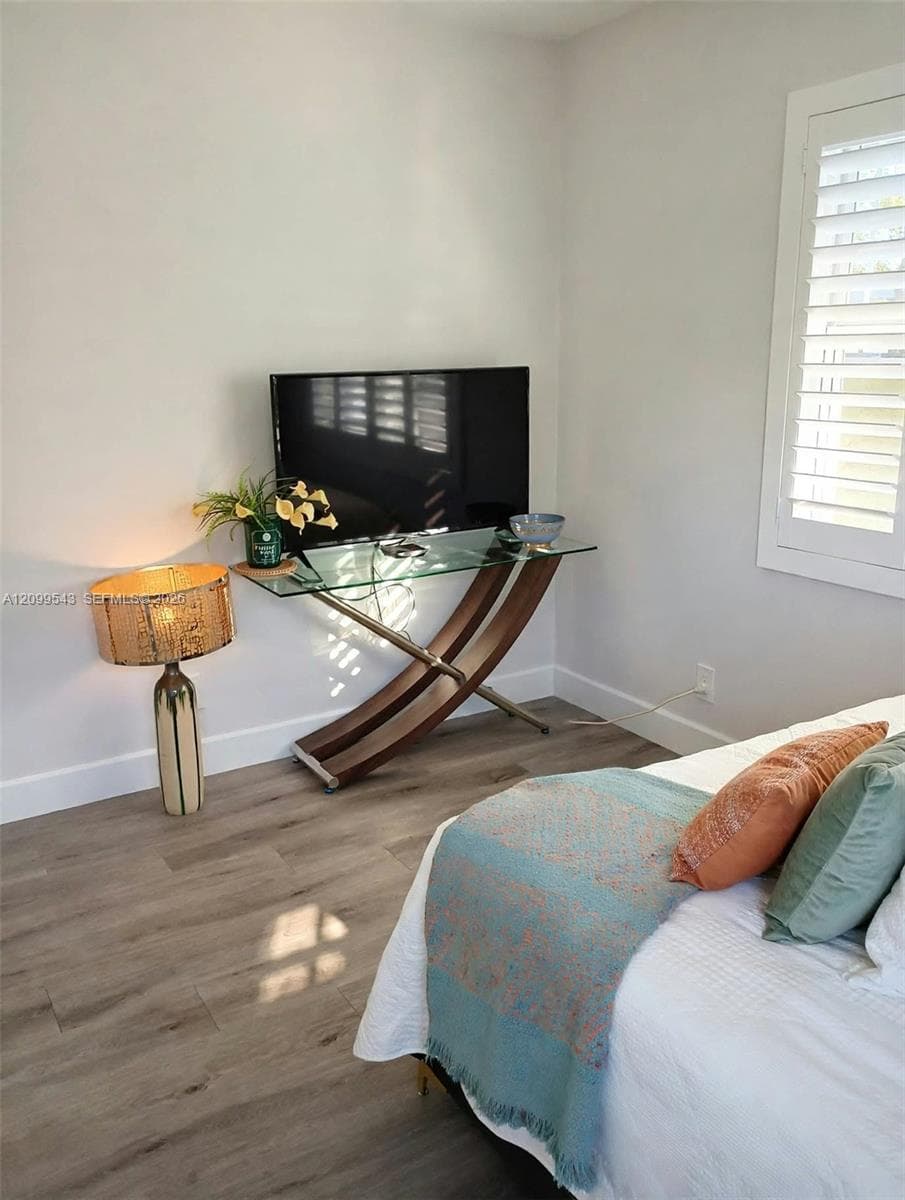 Wood-finish flooring, white walls, and interior window shutters