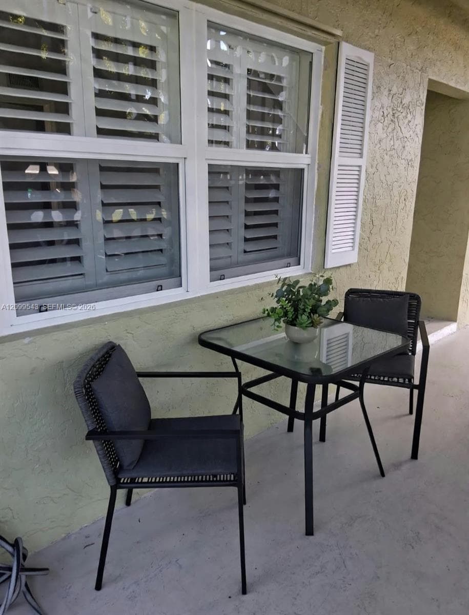 Exterior window with white frames and integrated white shutters, finished with a smooth stucco wall texture